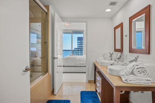 a white bathroom with two sinks and a shower at Splendid Unit outstanding View-W Hotel Brickell in Miami