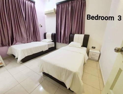 2 łóżka w pokoju z fioletowymi zasłonami w obiekcie Sunrise Homestay w mieście Alor Setar