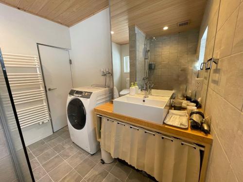 a bathroom with a sink and a washing machine at The Bunker at Yunosato in Rankoshi