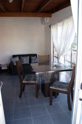 a dining room with a table and chairs and a couch at La cabaña 5y15 in Playa Hermosa