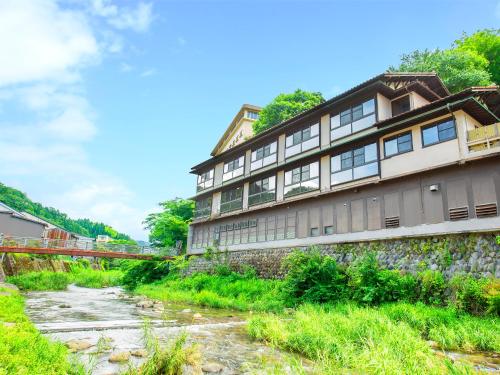 a building on the side of a river at Yukai Resort Premium Miyoshiya in Shinonsen
