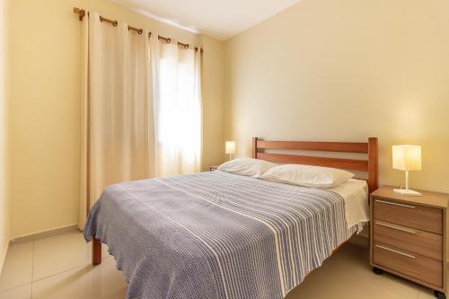 - une chambre dotée d'un lit avec une couverture bleue et blanche dans l'établissement Oscar Freire Apart, à São Paulo