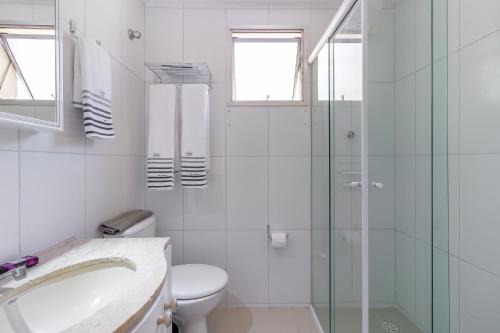 a bathroom with a toilet and a glass shower at Oscar Freire Apart in Sao Paulo