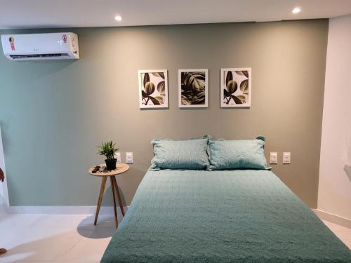 a bedroom with a bed with a green bedspread at Espetacular Flat em Miramar 2 in João Pessoa