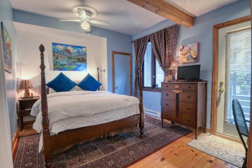 Un dormitorio con una cama con paredes azules y una ventana en La Loggia Art B&B, en Montreal