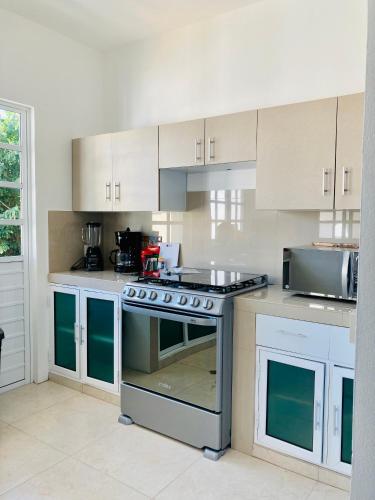 a kitchen with white cabinets and a stove top oven at Homecancun in Cancún