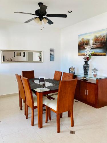 a dining room with a table and chairs and a ceiling fan at Homecancun in Cancún