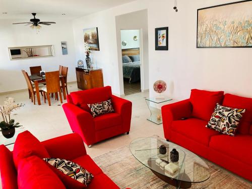 a living room with red couches and a table at Homecancun in Cancún