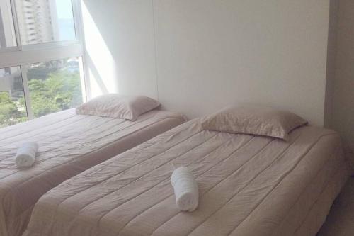 two twin beds in a room with a window at Pozos colorado Bello horizonte - Apartamento 70 mt2 in Santa Marta