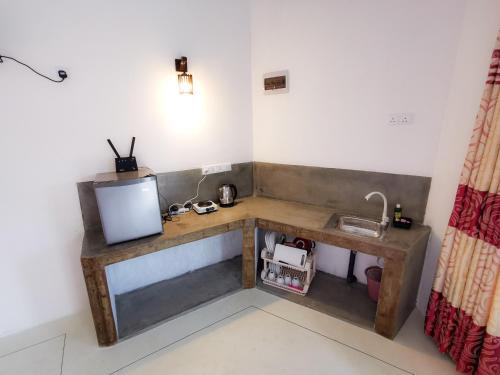 a room with a wooden desk with a television at Laguna Surfing Stay in Midigama