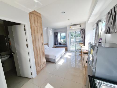 ein Wohnzimmer mit einem Bett und einer Küche in der Unterkunft Des Res Hotel and Residence in Bangna