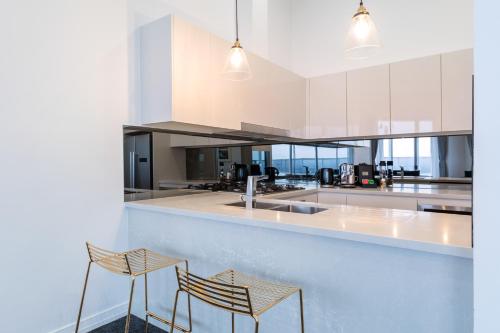 a kitchen with two chairs and a counter at Meriton Suites Bondi Junction in Sydney