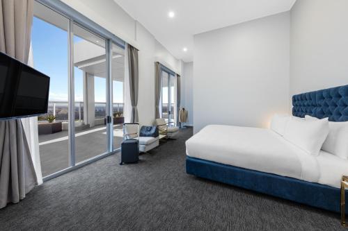 a hotel room with a bed and a large window at Meriton Suites Bondi Junction in Sydney