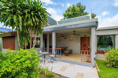 a house with a patio with a table and chairs at Wandee Garden in Choeng Mon Beach