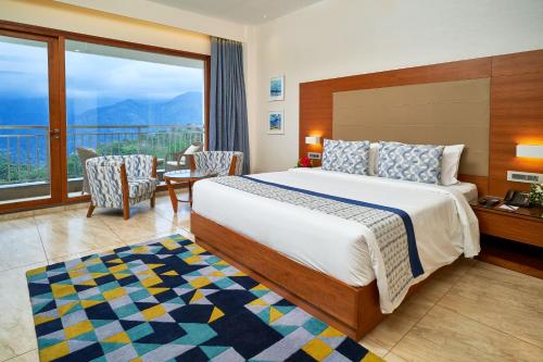 a hotel room with a bed and a balcony at Vibe Munnar in Munnar