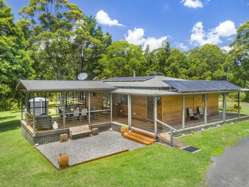 a house with a solar roof on a yard at Cedar House in Kangaroo Valley