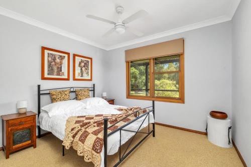 a bedroom with a bed and a window at Cedar House in Kangaroo Valley