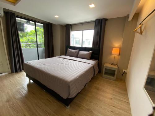 a bedroom with a bed and a large window at Bansuay Bangkadi in Pathum Thani