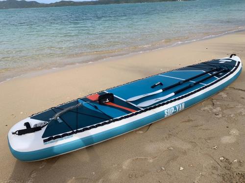 a blue and white boat sitting on the beach at Le Grand Bleu in Amami