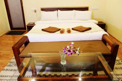 a hotel room with a bed with a glass table with a glass table at Agonda Wellness in Agonda