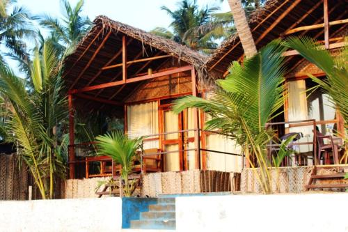 a house on the beach with palm trees at Agonda Wellness in Agonda