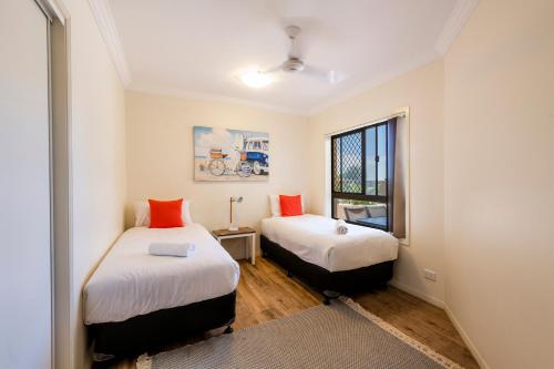 two beds in a small room with a window at Breakers 1 3 LJHooker Yamba in Yamba