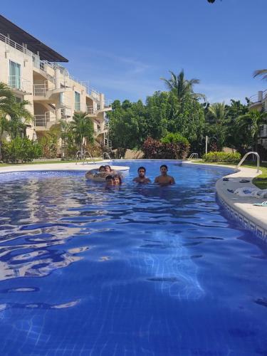 a group of people swimming in a swimming pool at depto relajante Diamante in Acapulco
