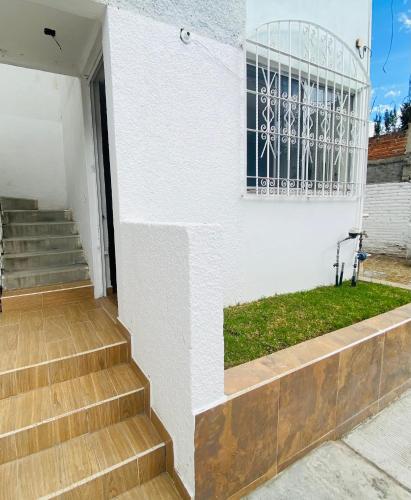a white house with stairs and a window at Cómodo y Pintoresco Depa Al sur de La Ciudad! in León