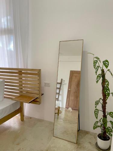 a mirror in a room with a chair and a plant at Secret Spot Siargao in General Luna