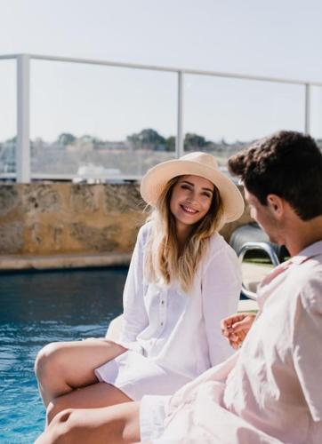 a woman in a hat sitting next to a man at Pier 21 Riverside Apartment Hotel in Fremantle