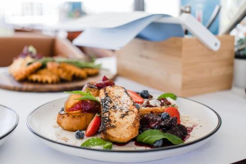 a plate of food with meat and vegetables on a table at Pier 21 Riverside Apartment Hotel in Fremantle