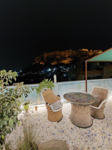 a table and chairs on a patio at night at Blue Stay Jodhpur in Jodhpur