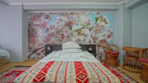 a bedroom with a bed and a floral wall at Vila Muntii Bucegi & SPA in Bran