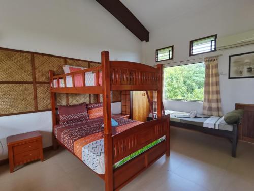 a bedroom with two bunk beds and a window at Nickles Park Resort in Panglao Island