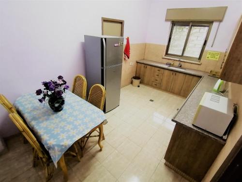 a small kitchen with a table and a refrigerator at House of Peace in Bethlehem
