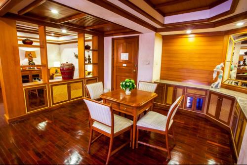 a dining room with a wooden table and chairs at Felix River Kwai Resort - SHA Plus,Certified in Kanchanaburi