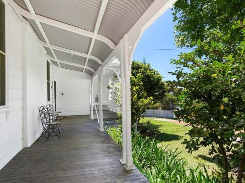 a covered porch of a white house with chairs and trees at Blake House - SPECIAL OFFER STAY 3 PAY for 2 OR 25PERCENT OFF MIDWEEK in Kiama