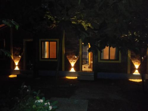 a house with lights in front of it at night at Palm Beach Resort in Kumta