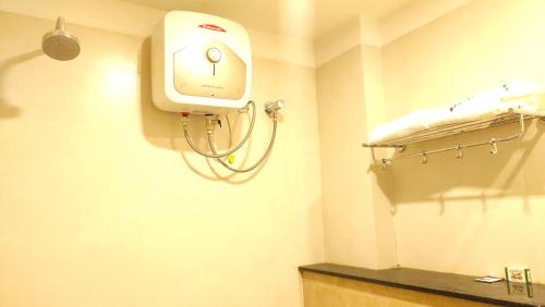 a hospital room with a bed and a hair dryer at Hotel Rhythm Grand Suite in Tiruchchirāppalli