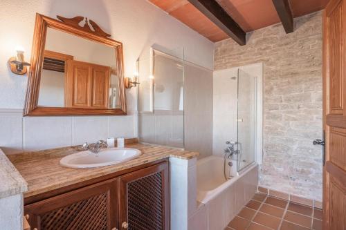 a bathroom with a sink and a shower and a mirror at Es turo de Mallorca in Ses Salines