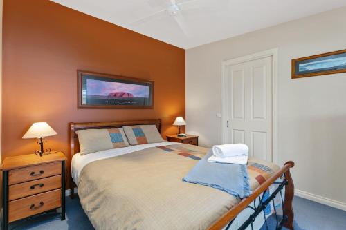 une chambre avec un lit et une télévision au mur dans l'établissement Apollo Bay Hideaway 5 minute walk to the beach, à Apollo Bay