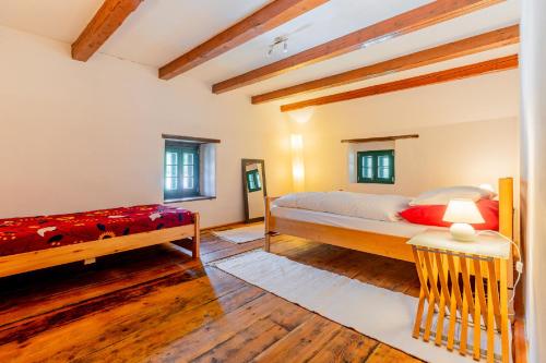a bedroom with two beds in a room with wooden floors at Mühle in der Pferdewelt Reichenau in Reichenau