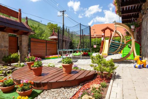 a garden with a wooden deck and a playground at Goralturist in Ždiar