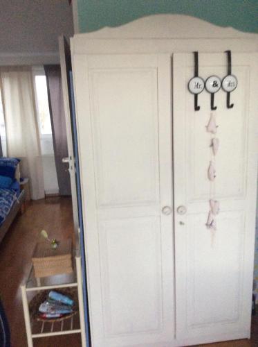 a room with a white closet with scissors on the door at Dachstudio mit Bad und Terasse in Cologne