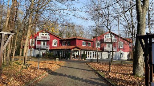 a large red house in the middle of a forest at Hotel Rosengarten Leipzig-Naunhof in Naunhof