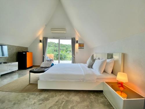 1 dormitorio con 1 cama blanca grande y TV en Laguna Pearl Private Pool Villa - Koh Chang en Ko Chang