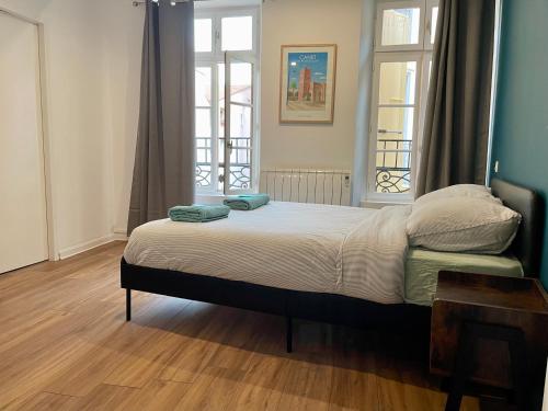 a bedroom with a bed with two pillows on it at République - Grande la Réal in Perpignan