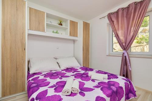 Un dormitorio con una cama púrpura y blanca y una ventana en Apartments BARO en Maranovići