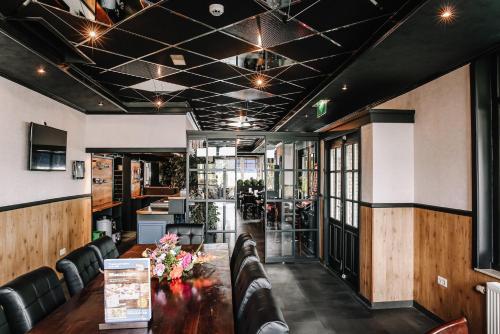 a dining room with a table and leather chairs at Hotel Frans op den Bult in Deurningen