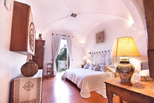 a bedroom with a bed and a table with a lamp at Hotel Boutique La Casa Azul in Cuernavaca